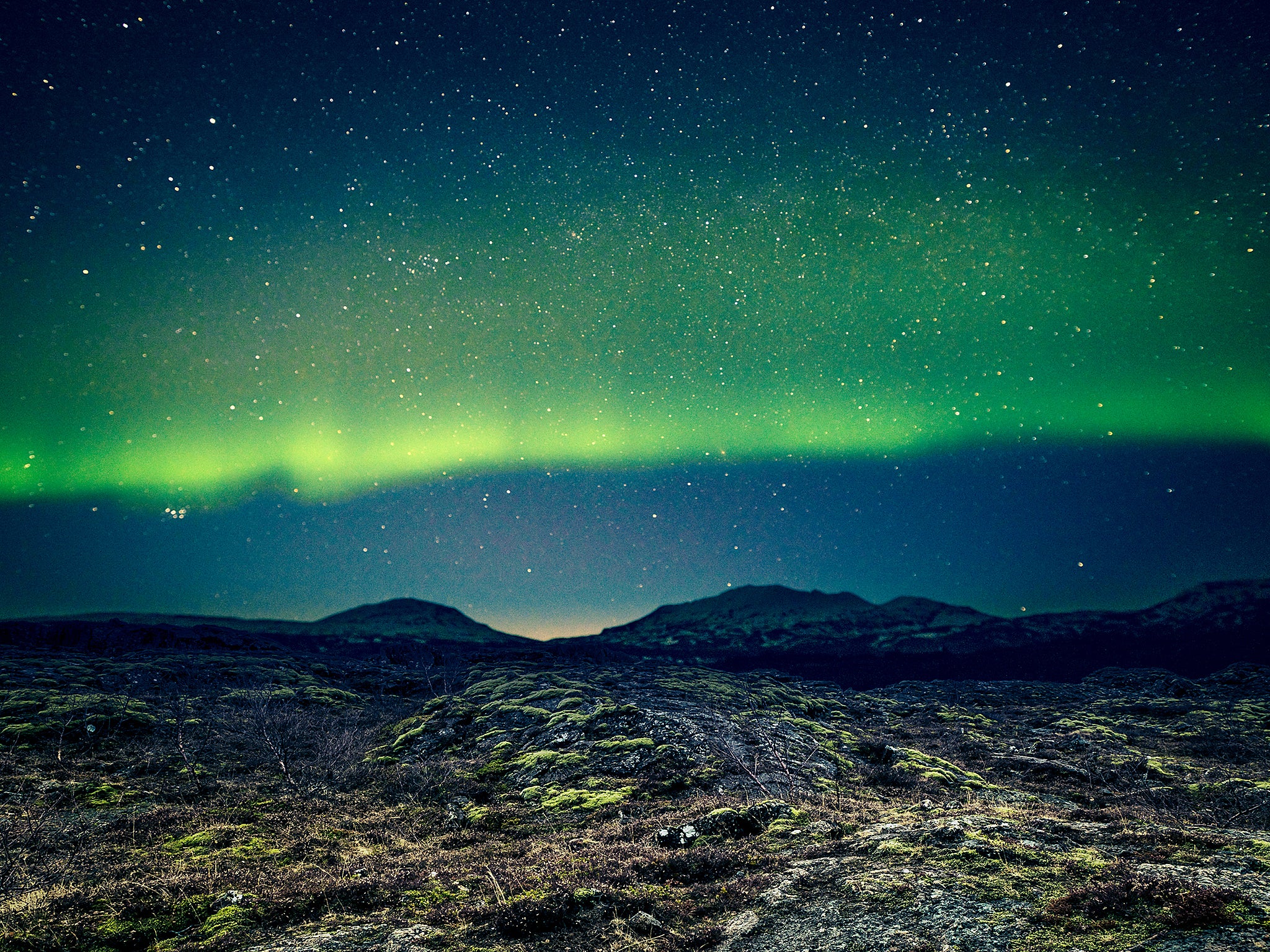 Aurora Borealis over distant mountains in Iceland