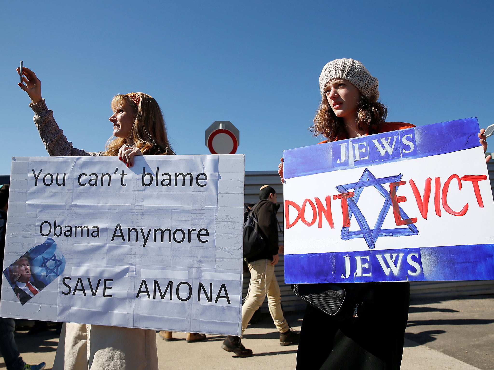 Protesters hold placards during a demonstration against the expected eviction of the Israeli settler outpost of Amona in the occupied West Bank, in Jerusalem