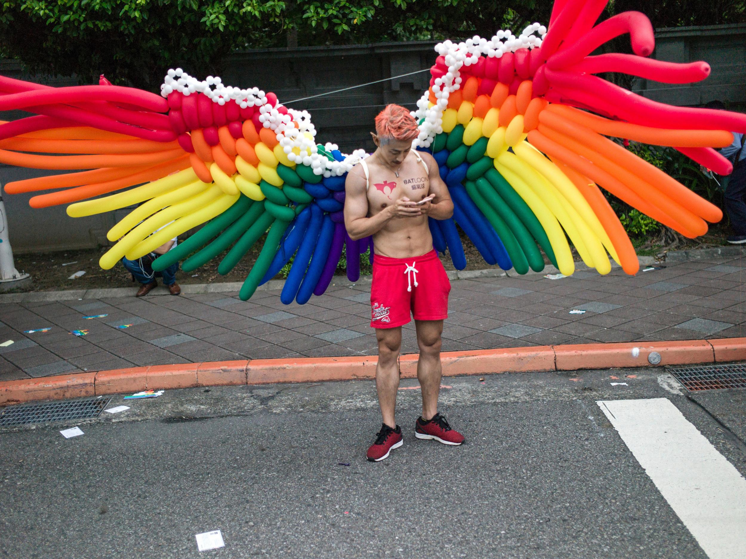 A man wears a pair of wings made with balloons during the annual Taiwan lesbian, gay, bisexual and transgender pride parade in Taipei