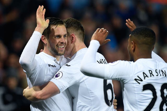 Gylfi Sigurdsson celebrates with his team-mates after scoring Swansea's second