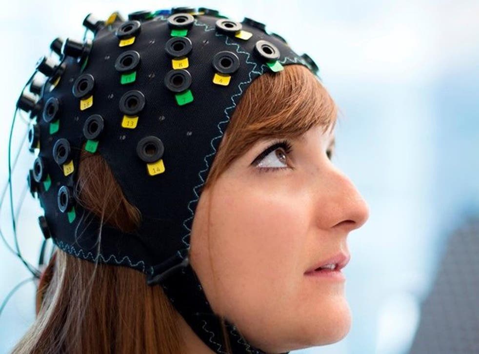 The cap uses infrared light to spot variations in blood flow in different regions of the brain (posed by a model)