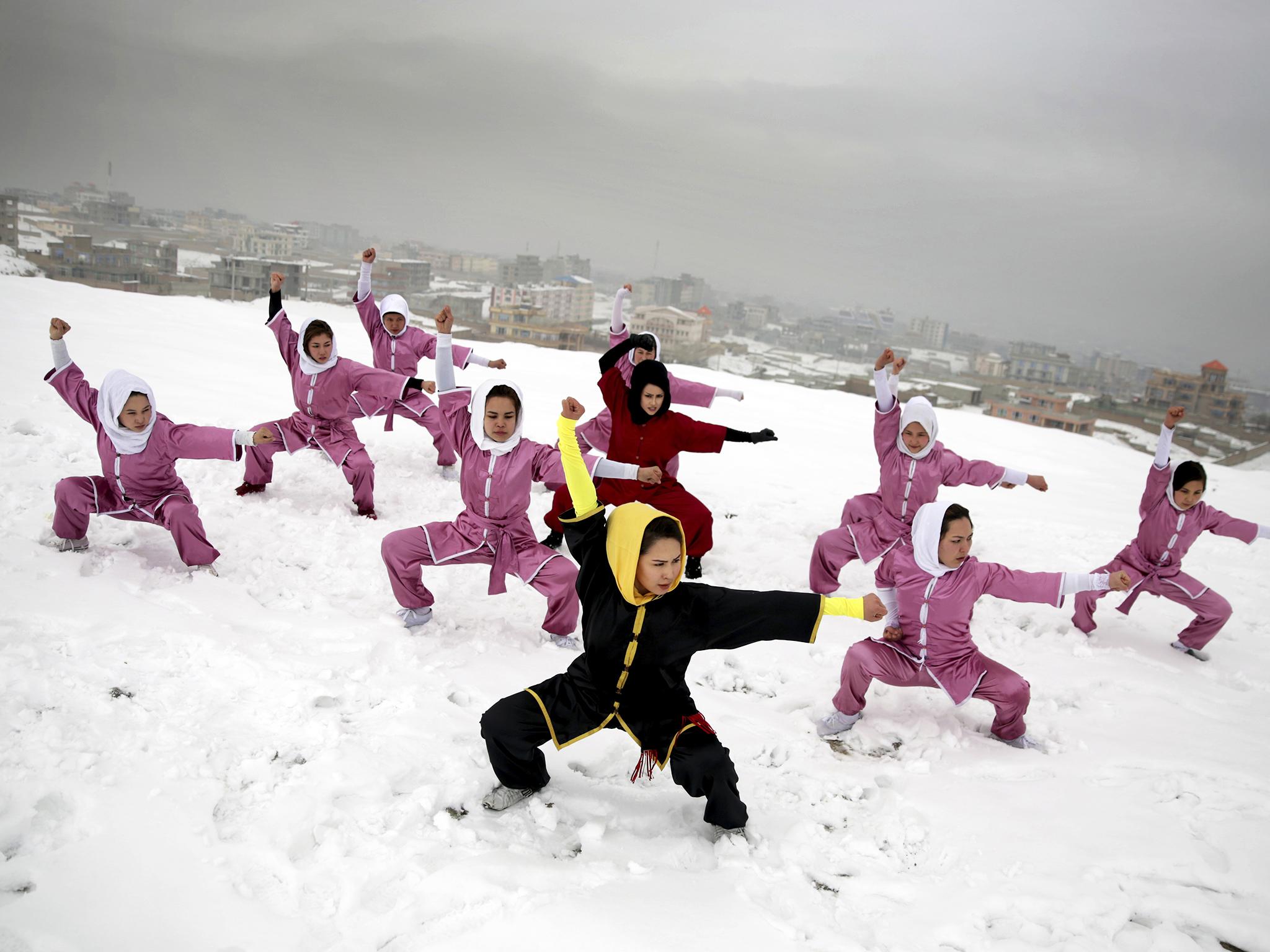 Shaolin martial arts students follow their trainer, Sima Azimi, 20, in black, during a training session on a hilltop in Kabul, Afghanistan