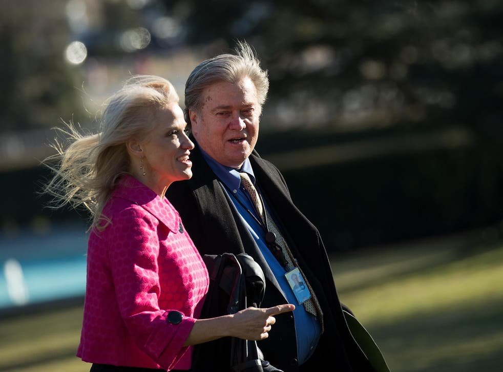 White House counselor Kellyanne Conway (L) and President Trump's chief strategist Steve Bannon walk toward the Oval Office on the South Lawn of the White House