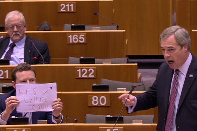 Labour MEP Seb Dance holds up a sign saying 'HE'S LYING TO YOU' as Nigel Farage praises Donald Trump in the European Parliament
