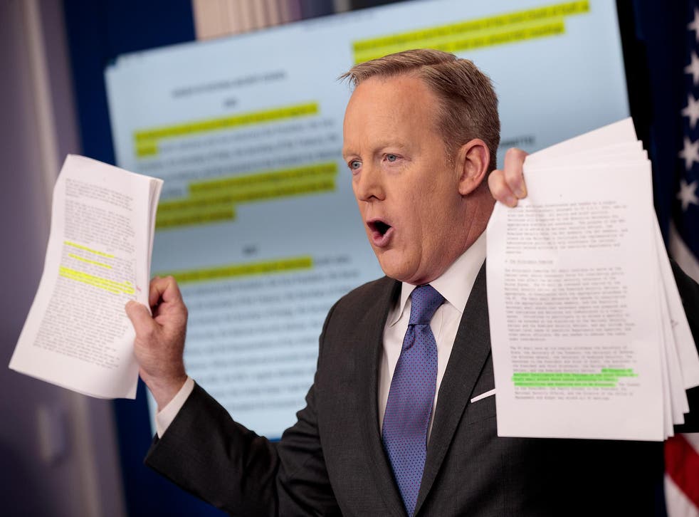 White House Press Secretary Sean Spicer holds up paperwork highlighting and comparing language about the National Security Council from the Trump administration and previous administrations during the daily press briefing at the White House