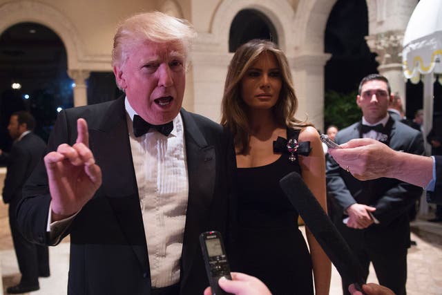 Donald Trump answers questions from reporters accompanied by wife Melania for a New Year's Eve party December 31, 2016