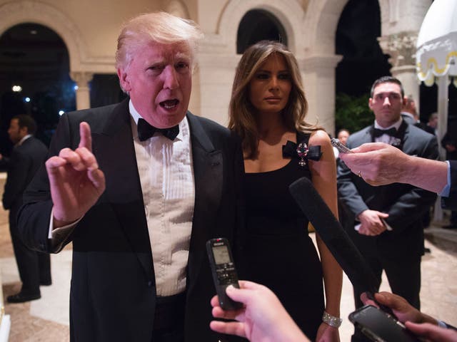 Donald Trump answers questions from reporters accompanied by wife Melania for a New Year's Eve party December 31, 2016