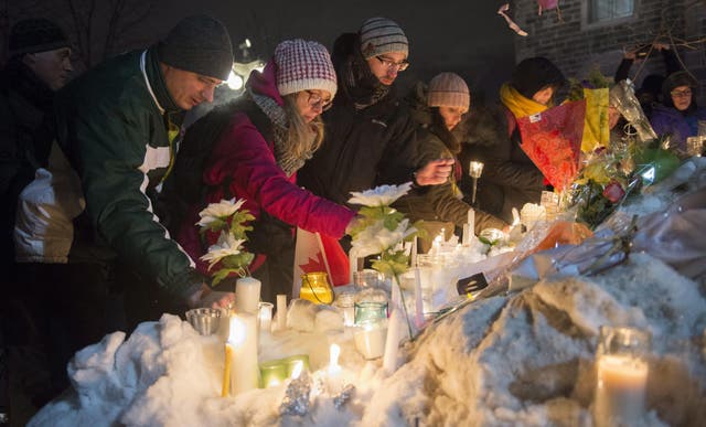 <p>People place candles during a 2020 vigil in Quebec City on Monday for victims of Sunday's deadly shooting at a Quebec City mosque</p>