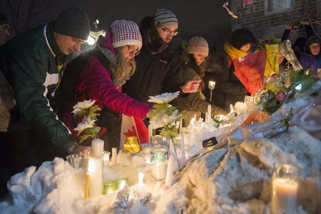 People place candles during a vigil in Quebec City on Monday for victims of Sunday's deadly shooting at a Quebec City mosque