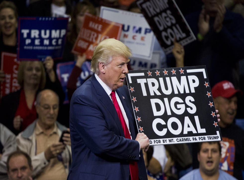 Republican presidential nominee Donald Trump holds a sign supporting coal during a rally at Mohegan Sun Arena in Wilkes-Barre, Pennsylvania on October 10, 2016