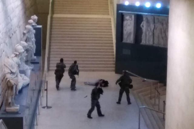 Photo taken by a tourist with a mobile phone shows a soldier opening fire at a man in the Louvre Museum