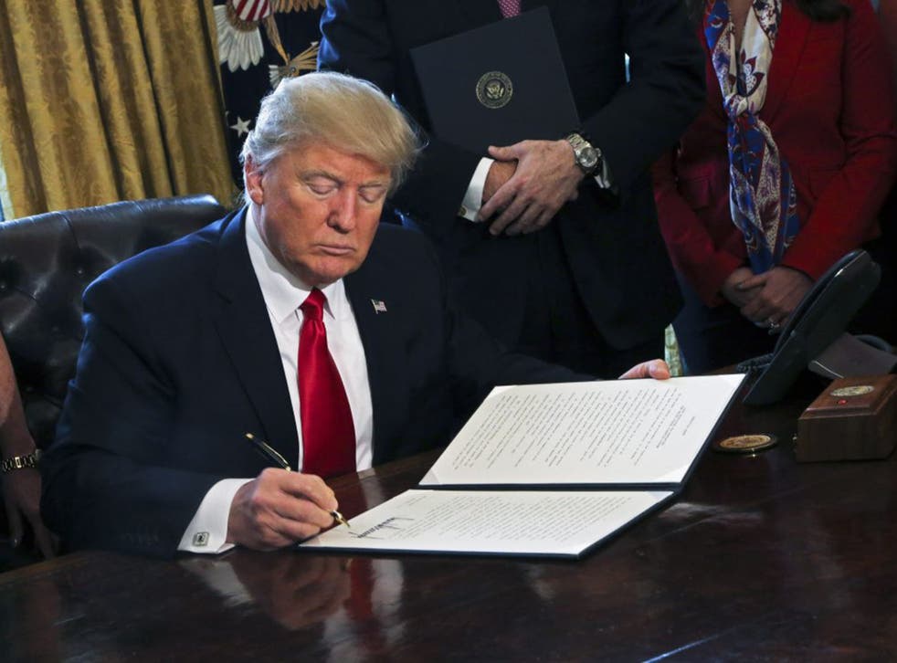 The President signs executive orders in the Oval Office of the White House on Friday