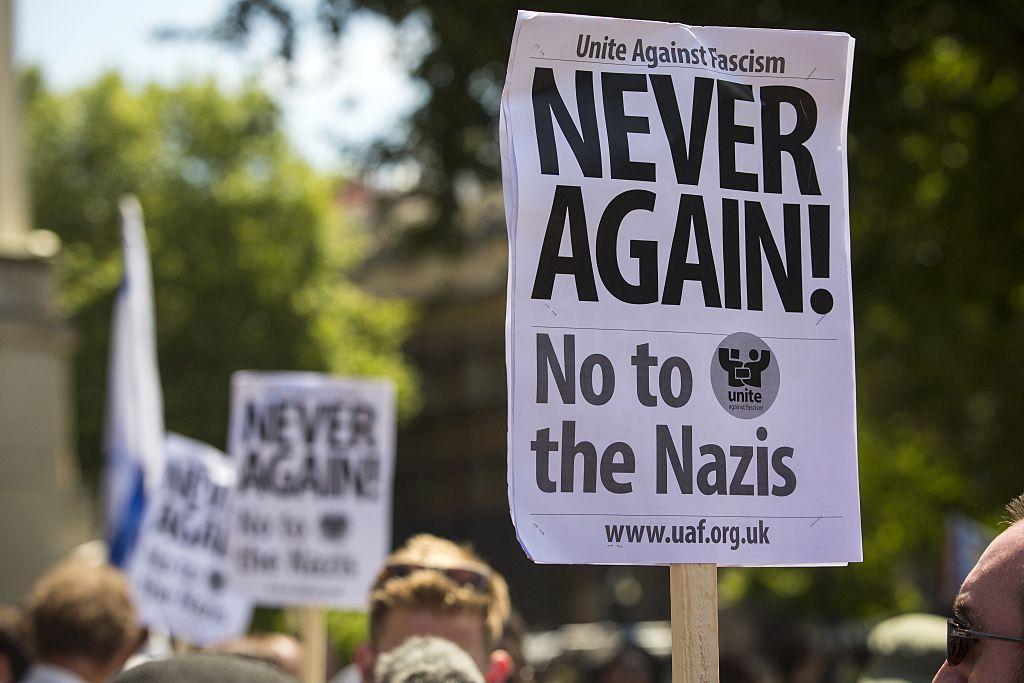 Anti-fascist demonstrators hold up placards at a central London anti-Jewish rally