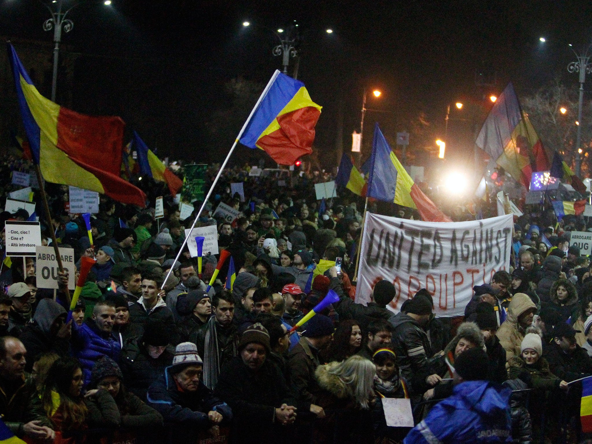 People wave Romanian flags during a protest in front of government headquarters in Bucharest, Romania, on 4 February
