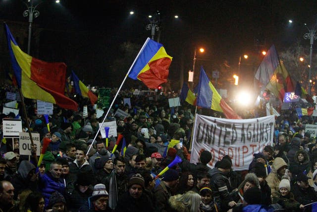 People wave Romanian flags during a protest in front of government headquarters in Bucharest, Romania, on 4 February