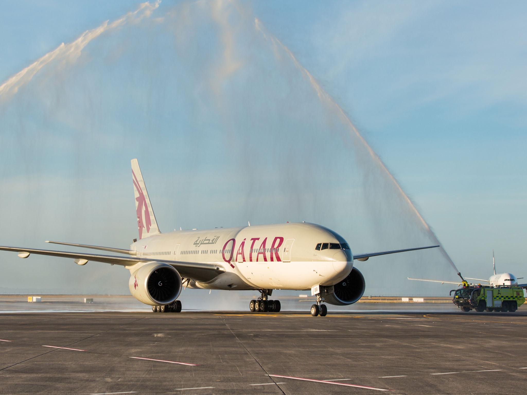 The flight from Doha is sprayed with water canons as it lands in Auckland