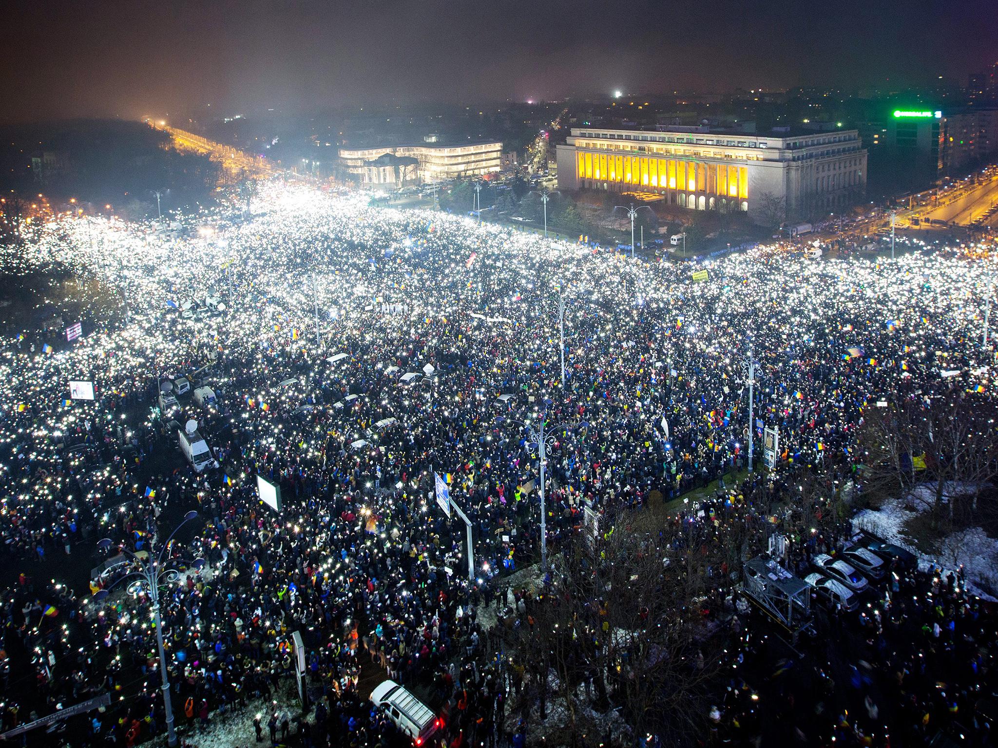 &#13;
Victoriei Plaza full of protesters flashing the lanterns on their cell-phones, all at the time, during a massive protest in front of government headquarters, background, in Bucharest, Romania &#13;