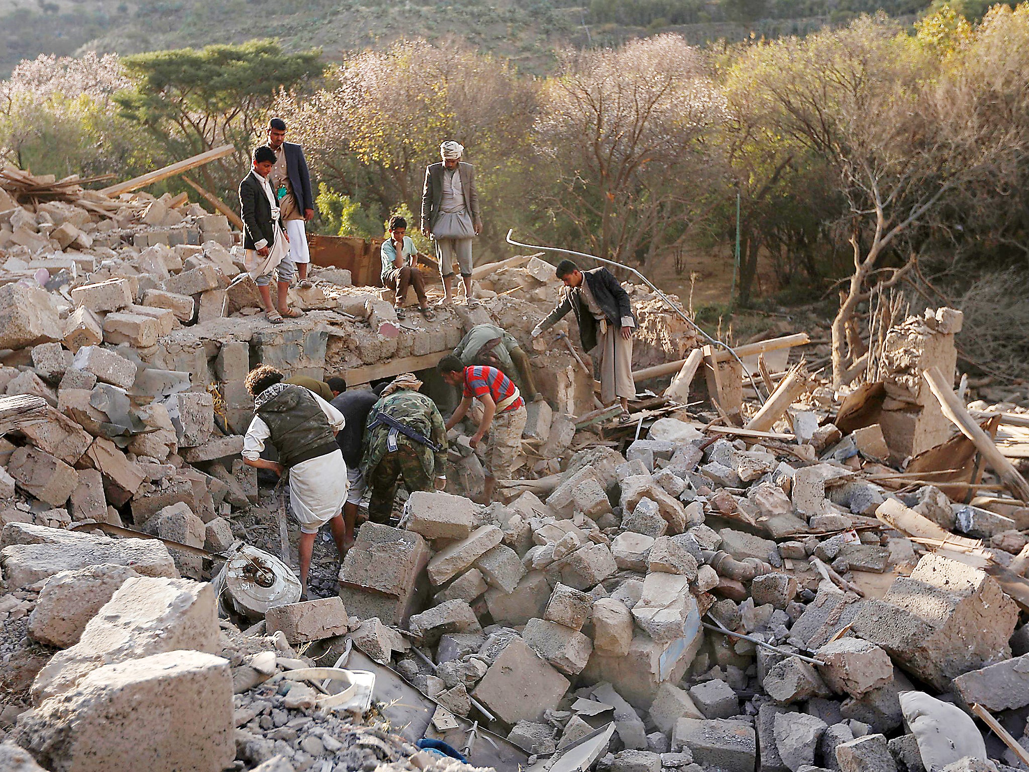 Yemenis inspect damaged houses following reported Saudi-led coalition air strikes on the outskirts of the Yemeni capital Sanaa