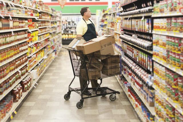 A supermarket worker stocks shelves