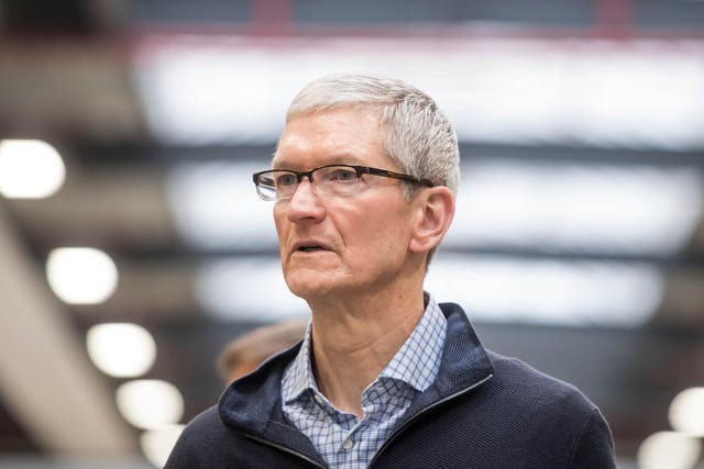 Apple CEO Tim Cook looks on during a visit of the shopfitting company Dula that delivers tables for Apple stores worldwide in Vreden, western Germany, on February 7, 2017