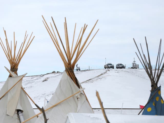 Police vehicles idle on the outskirts of the opposition camp against the Dakota Access oil pipeline near Cannon Ball, North Dakota