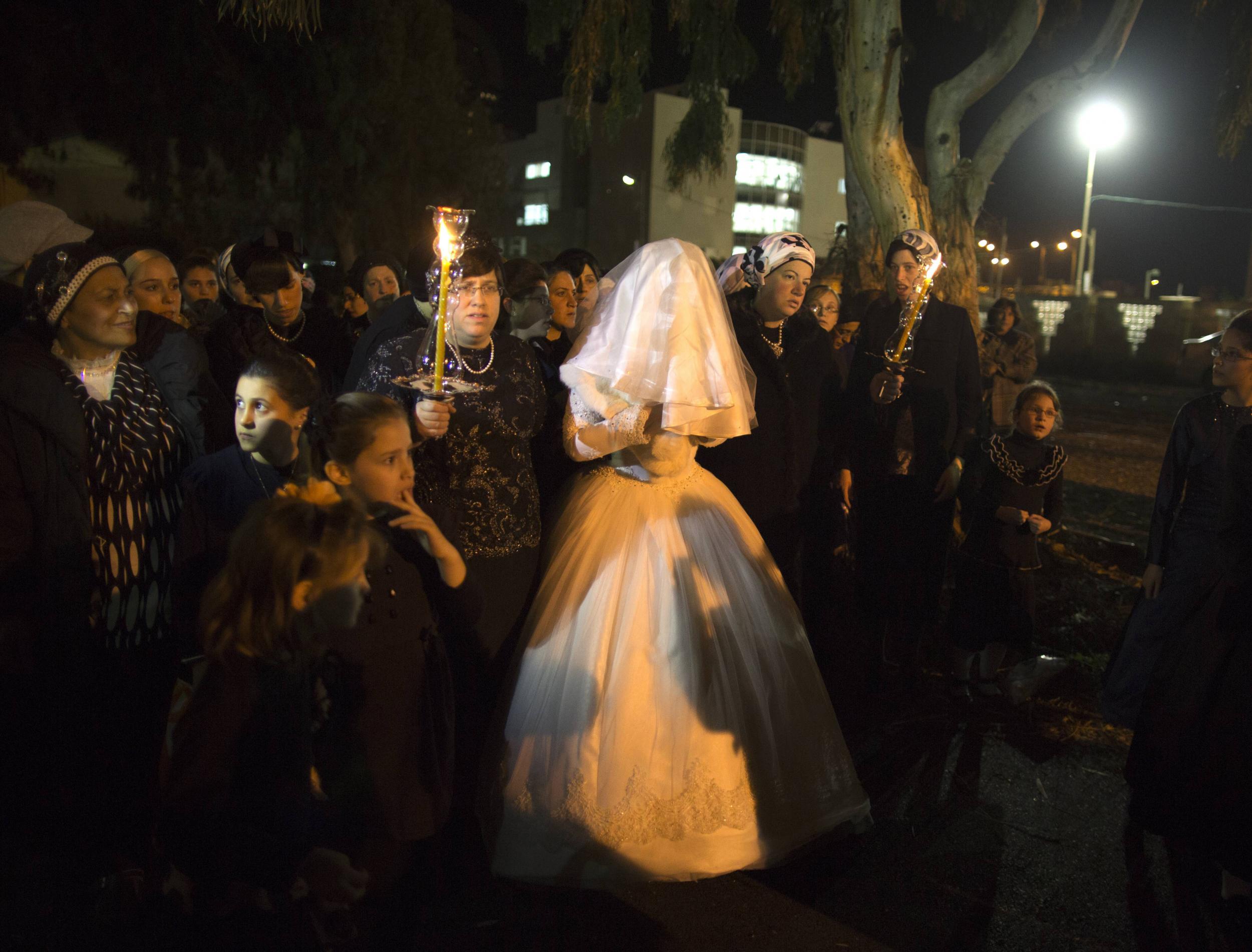 A Jewish woman arrives with family members for her orthodox wedding