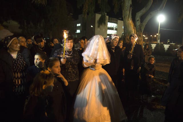 A Jewish woman arrives with family members for her orthodox wedding