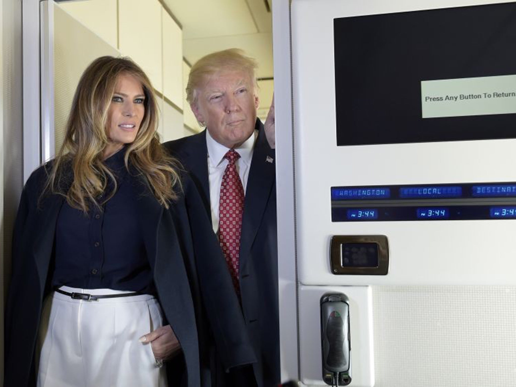 Donald Trump and first lady Melania talk with reporters on board Air Force One white travelling to Palm Beach, Florida