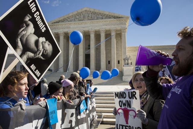 Pro-choice advocates (right) and anti-abortion advocates (left) rally outside of the Supreme Court, in Washington DC