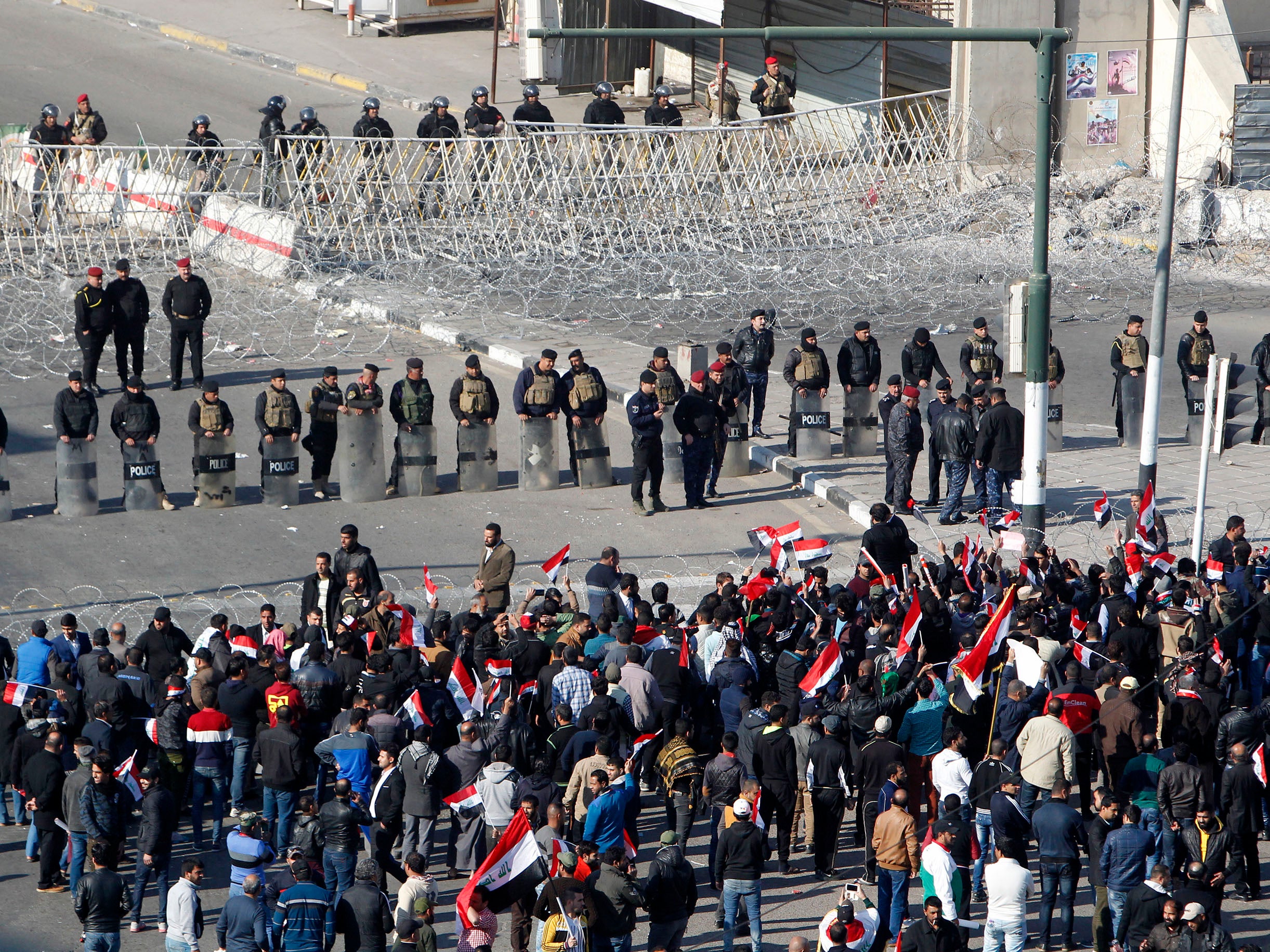 Iraqi security forces stand guard as Sadrist supporters demonstrate in Baghdad's Tahrir Square