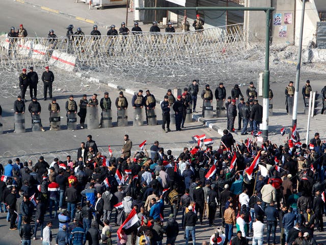Iraqi security forces stand guard as Sadrist supporters demonstrate in Baghdad's Tahrir Square