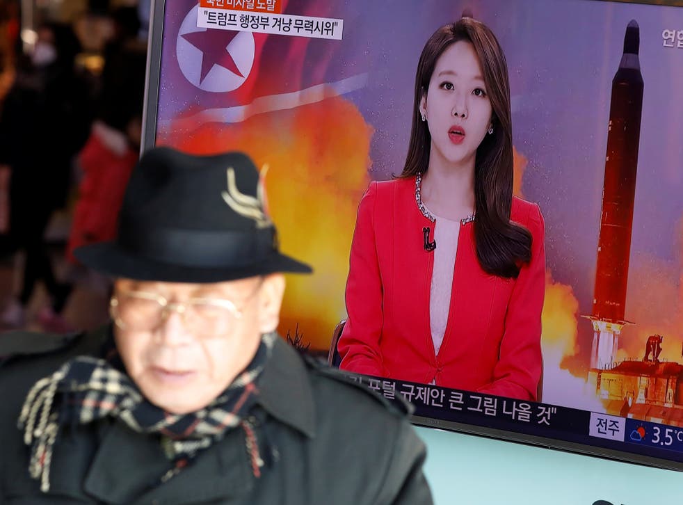 A TV screen broadcasts a news report on North Korea firing a ballistic missile into the sea off its east coast
