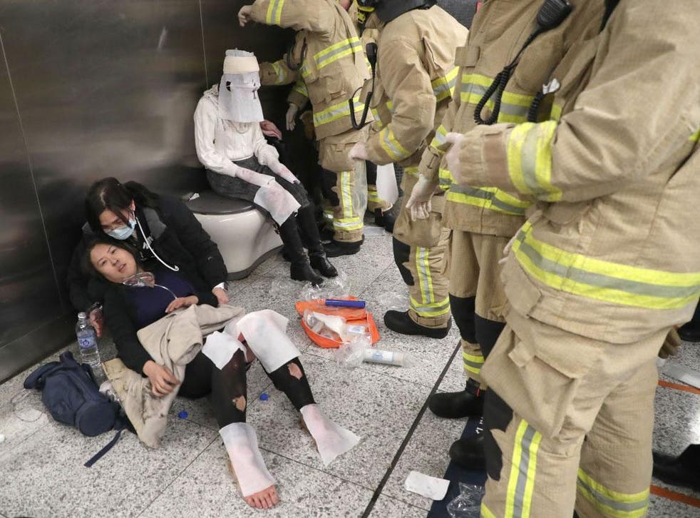 Commuters receiving first aid treatment from firefighters in Tsim Sha Tsui metro station in Hong Kong