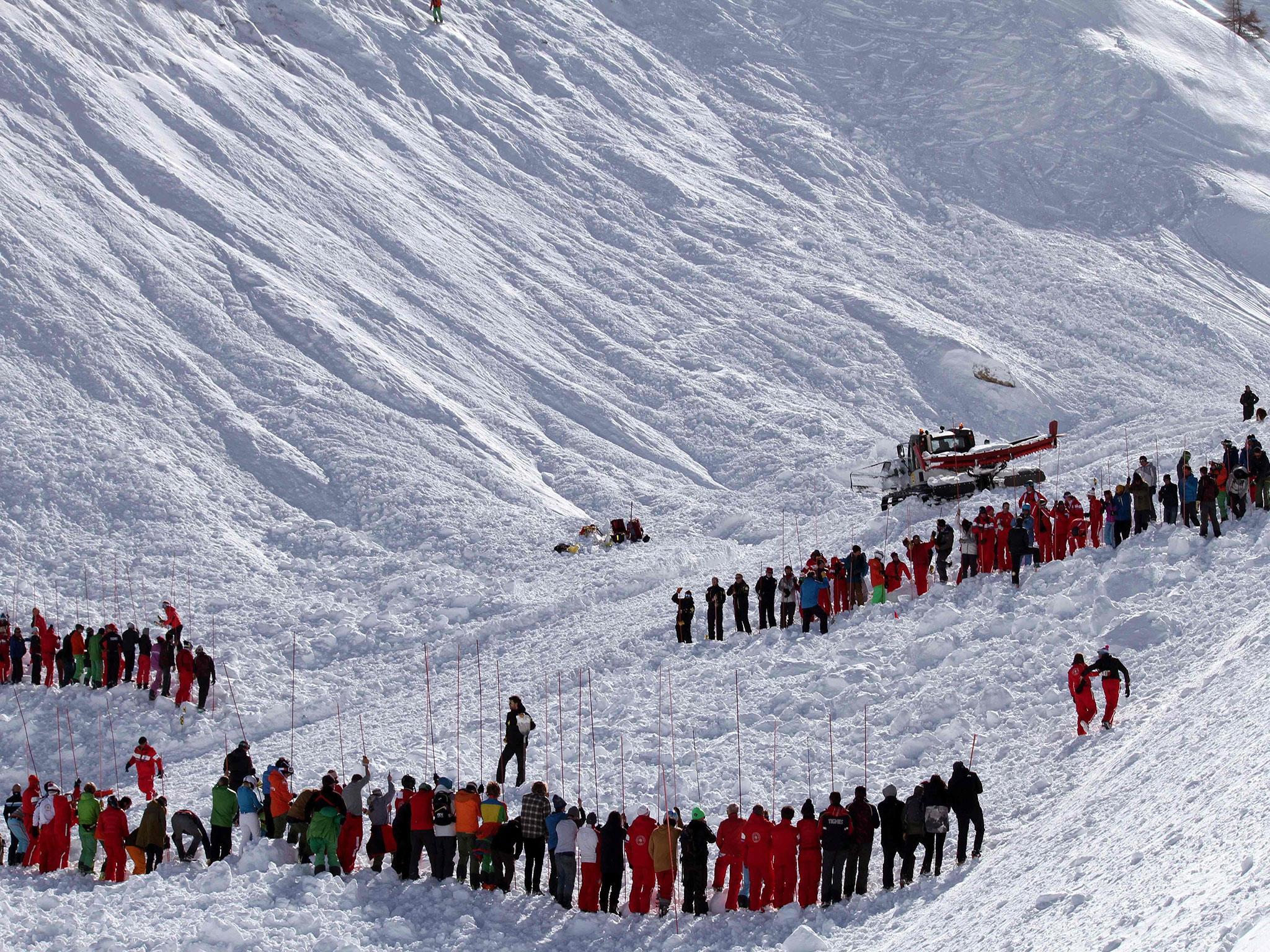 Rescuers workers search an avalanche site in an off-piste area