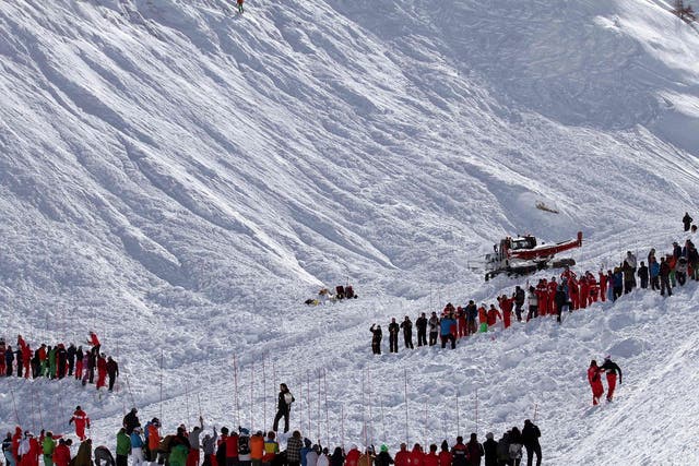 Rescuers workers search an avalanche site in an off-piste area