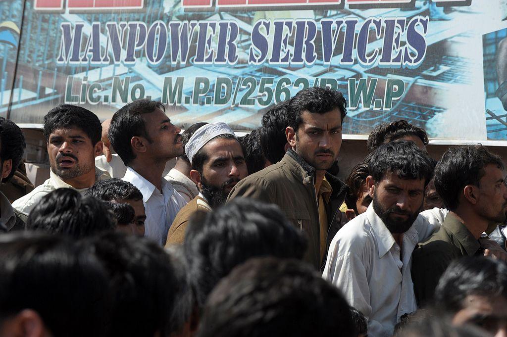 In this file photo Pakistani labourers gather outside the overseas employment consultant office in Rawalpindi on February 23, 2012 to apply for jobs with a construction company in Saudi Arabia