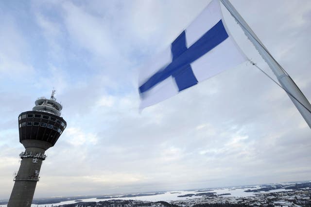The Finnish flag flies over a wintry landscape in the east of the country