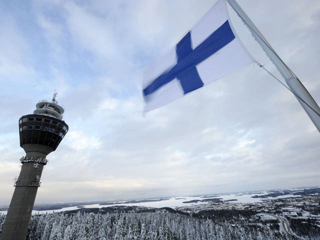 The Finnish flag flies over a wintry landscape in the east of the country