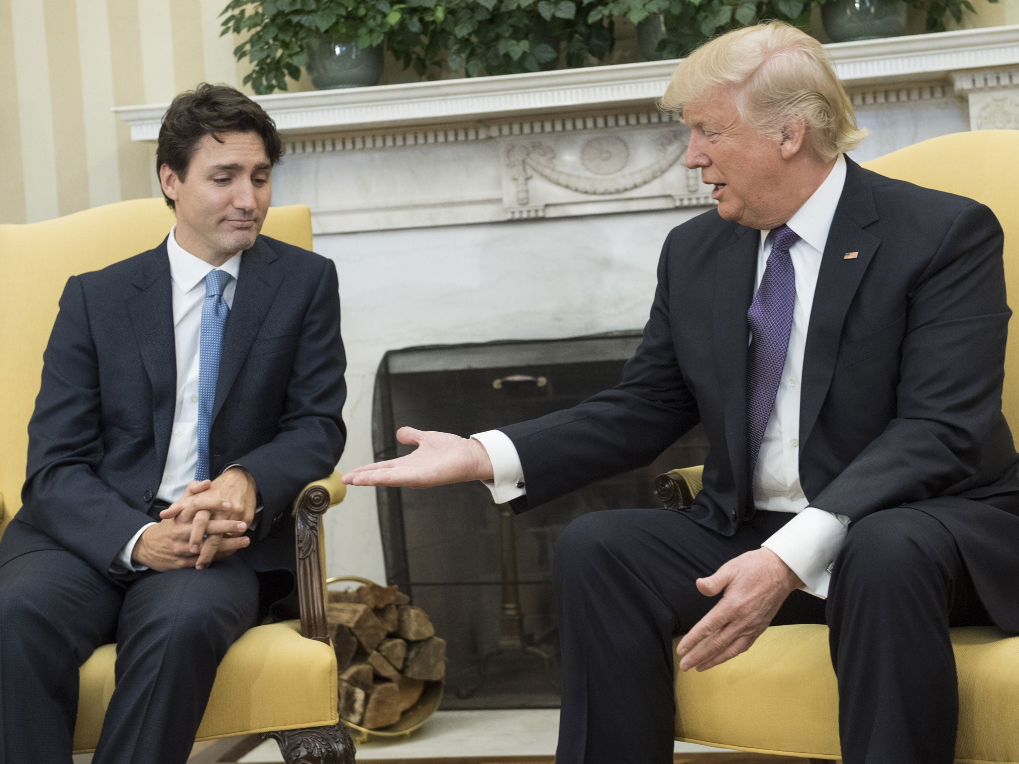 Donald Trump extends his hand to Prime Minister Justin Trudeau of Canada during a meeting in the Oval Office