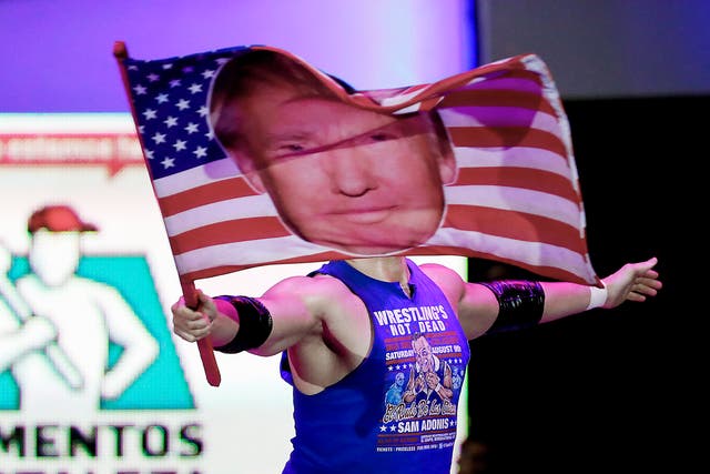American pro wrestler Sam Polinsky aka Sam Adonis takes the ring at Arena Mexico waving an American flag emblazoned with a photo of U.S. President Donald Trump, in Mexico City.  He's the guy Mexicans love to hate: The wrestler has become a sensation in Mexico City by adopting the ring persona of a flamboyant Trump supporter