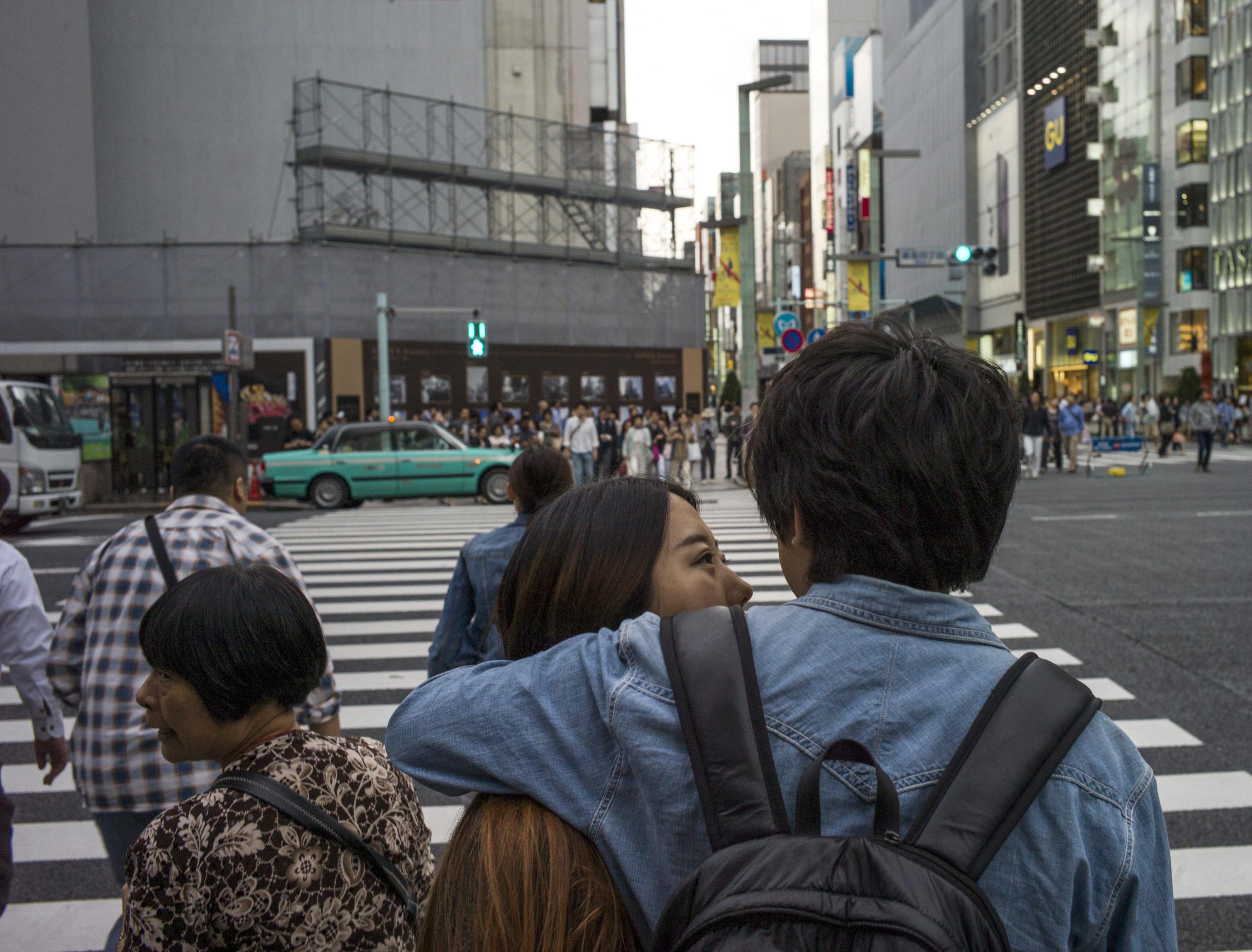 A couple speak at a zebra crossing in Ginza district in Tokyo