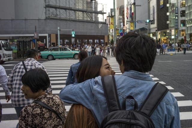 A couple speak at a zebra crossing in Ginza district in Tokyo