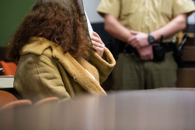Gabriele P. hides her face in court