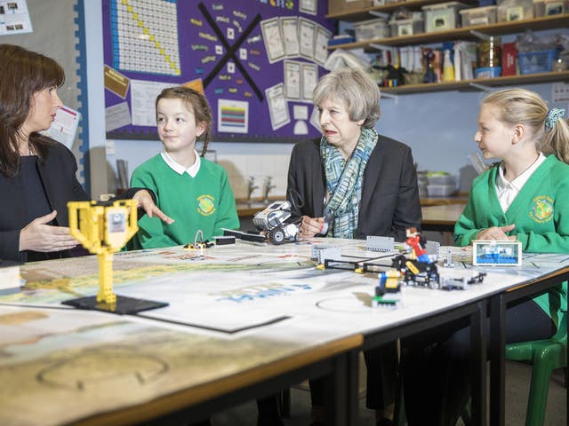 Theresa May (R) and Conservative Party candidate for the upcoming Copeland by-election, Trudy Harrison (L) sit with year six pupils during a visit to Captain Shaw's Primary School, in Bootle
