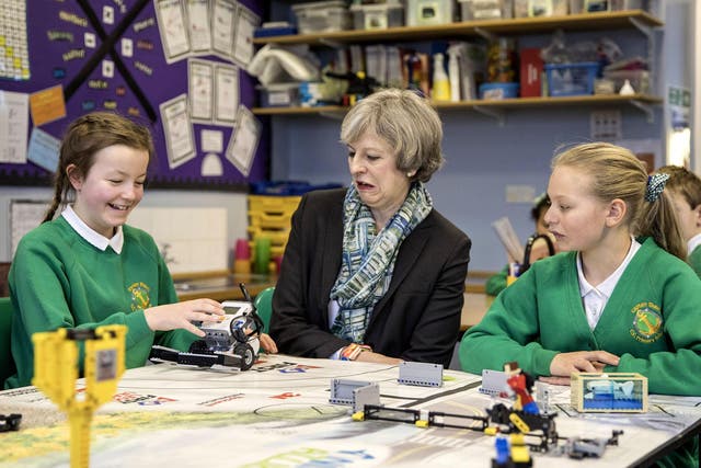 Theresa May sits with year six pupils during a visit to Captain Shaw's Primary School, Bootle