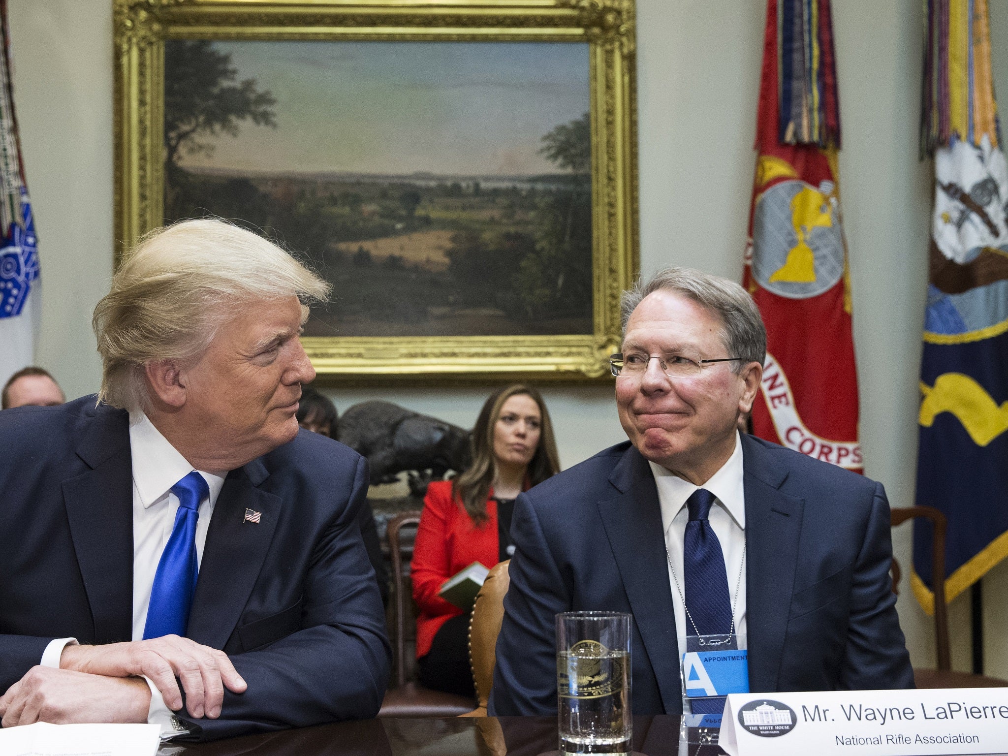 President Donald Trump sits beside Wayne LaPierre, the CEO of the National Rifle Association, who supports having armed guards in schools