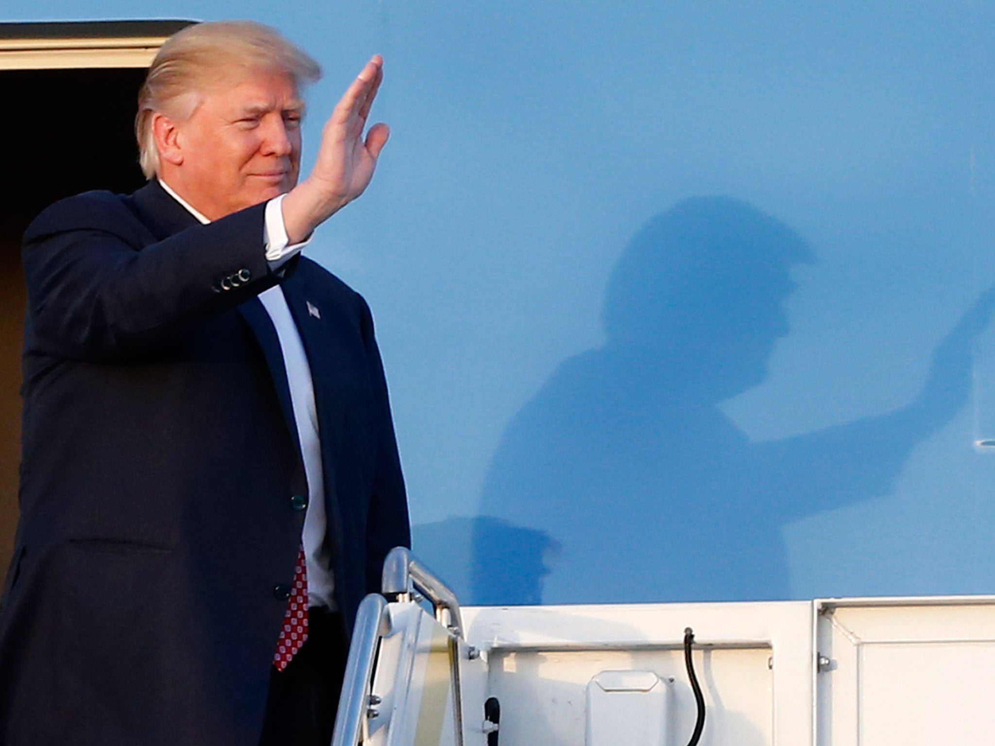 President Donald Trump waves to supporters on the steps of Air Force One