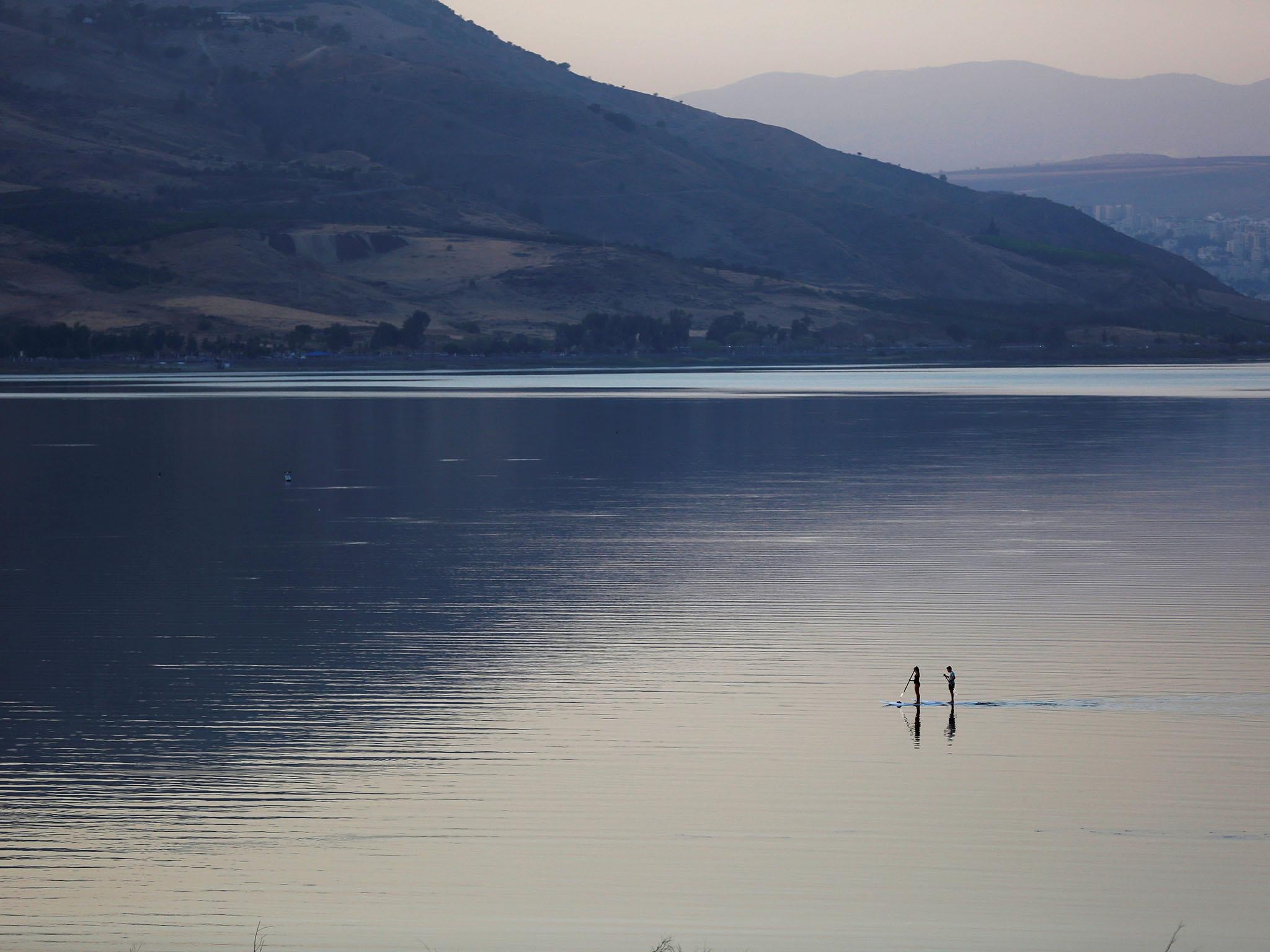 People paddle on a stand-up paddle board in the Sea of Galilee, northern Israel