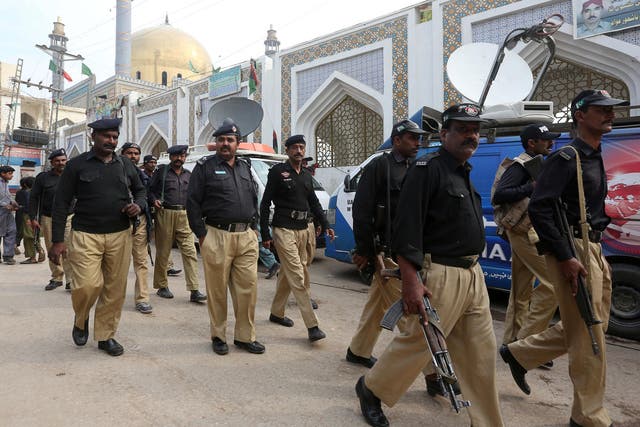 Policemen gather outside the tomb of Sufi saint Syed Usman Marwandi, also known as the Lal Shahbaz Qalandar shrine, after Thursday’s suicide blast in Sehwan