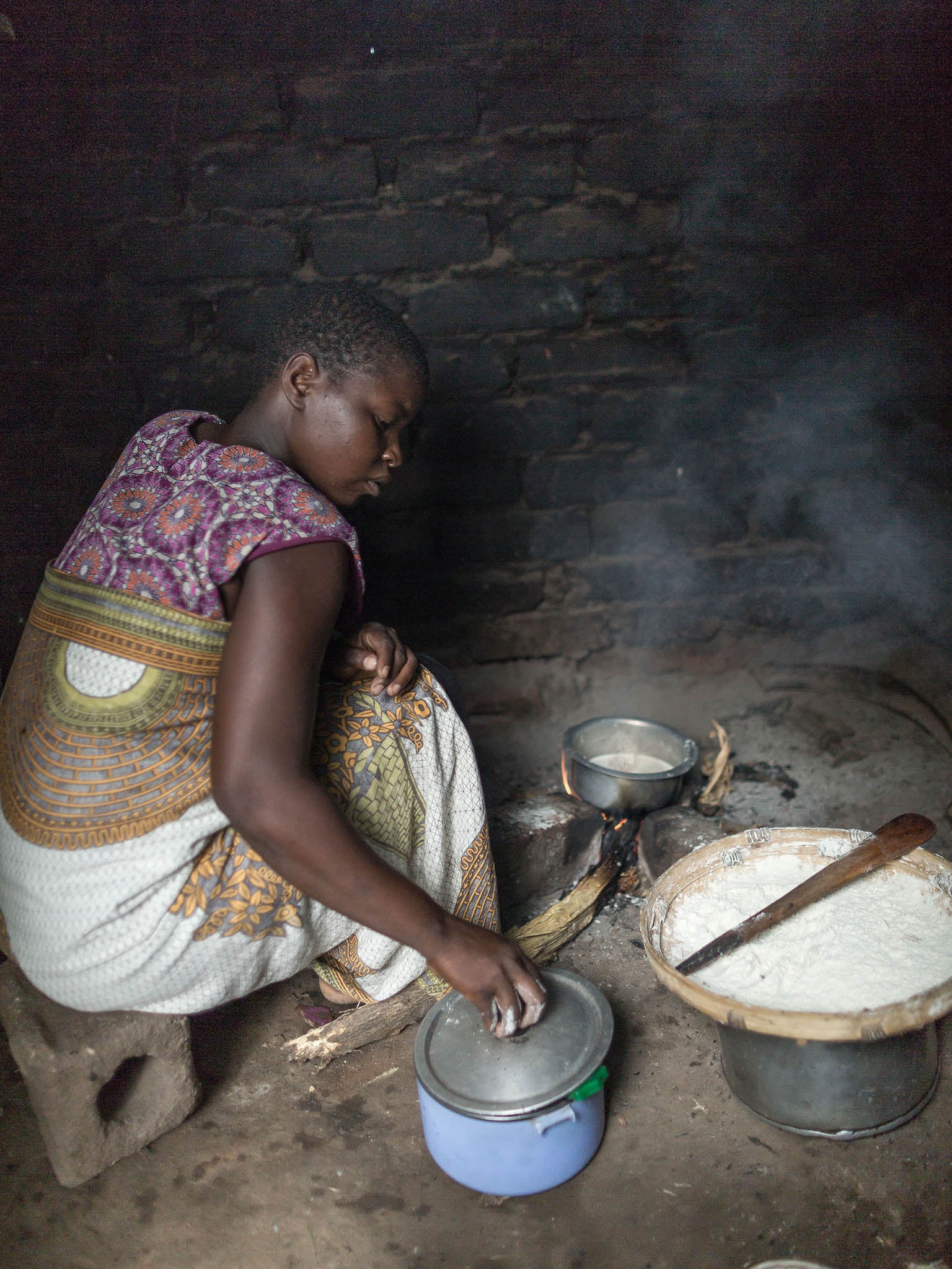 Cooking Nzima: m local staple of ground corn similar to polentaaize mash is a Malawian staple and served with every meal